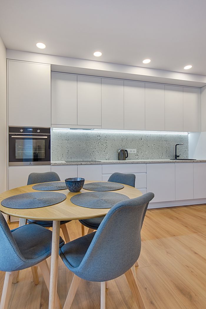 Sleek Scandinavian-style kitchen with wooden elements and minimalistic decor in a modern apartment.