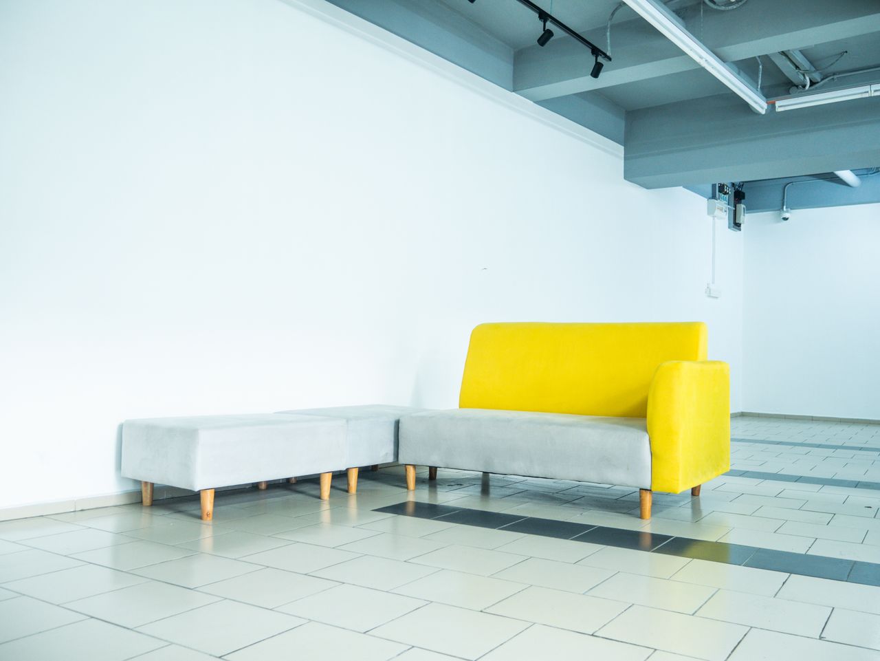 Mastering the First Impression: Your intriguing post title goes here Bright yellow and gray minimalist couch in a contemporary Kuala Lumpur interior.